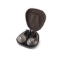 Un paio di cuffie Focal Bathys MG con un design in metallo perforato si trova in una custodia marrone aperta accanto a un cavo audio a spirale.
