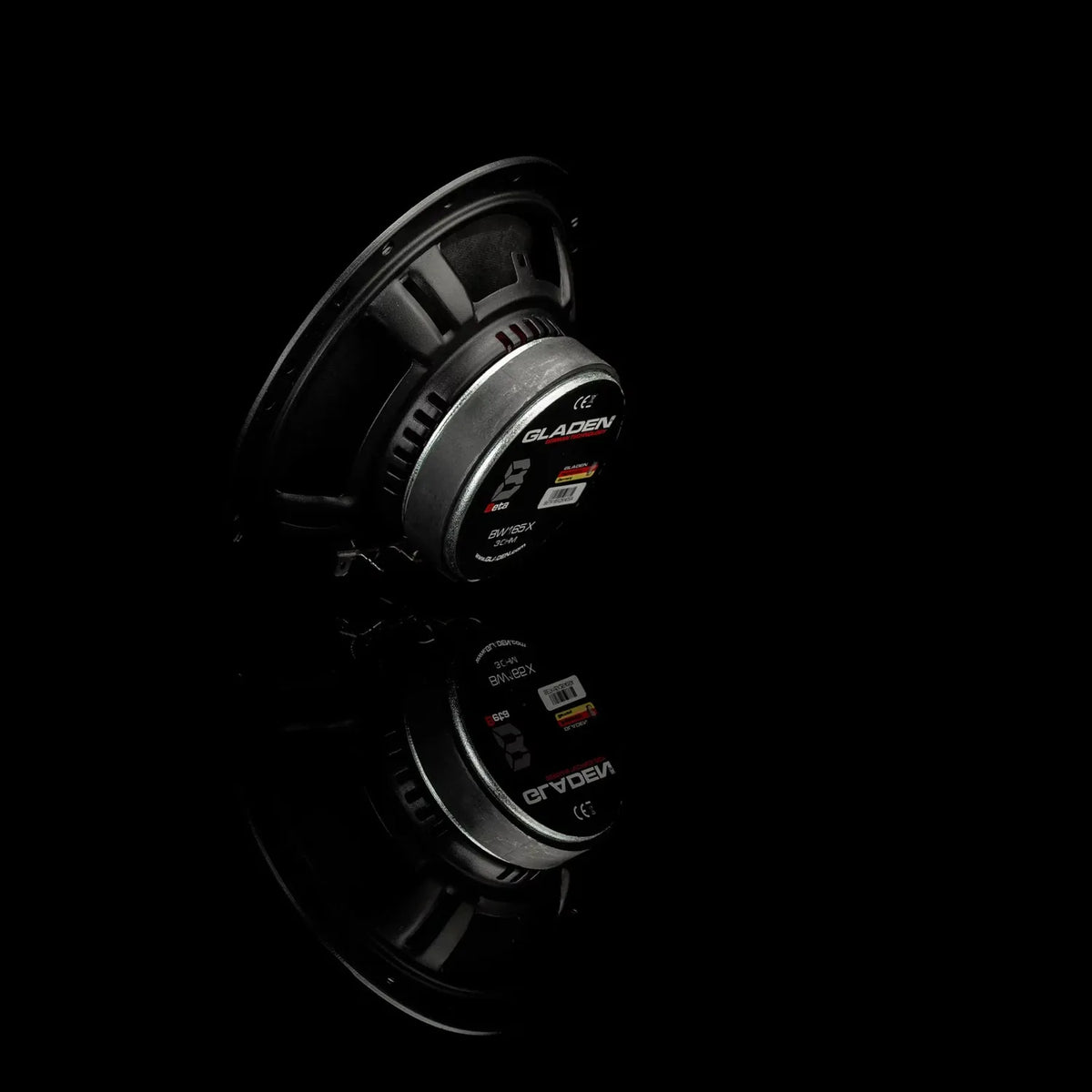A Gladen BETA 165-X speaker is shown on a black background with its reflection visible below.
