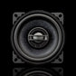 Une enceinte Gladen Gamma 100-X noire et ronde, dotée dune grille centrale sur un cadre carré, photographiée sur un fond noir avec un léger reflet en dessous.
