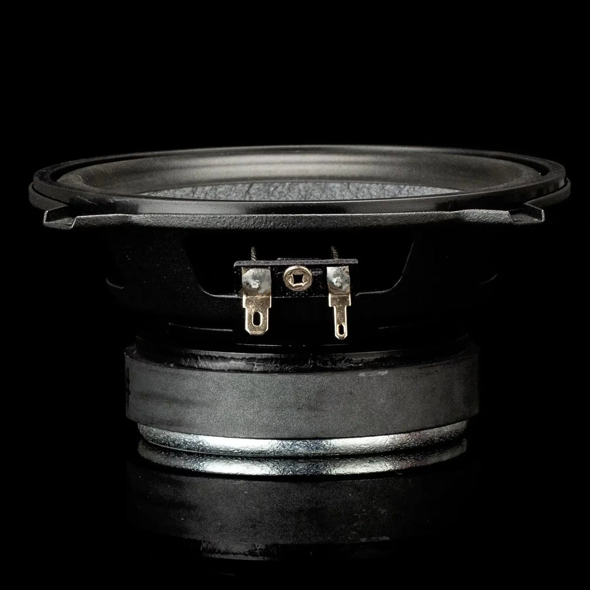Un gros plan sur le haut-parleur Gladen Gamma 130.2, doté de deux connecteurs métalliques qui mettent en valeur la qualité sonore sur un fond noir.