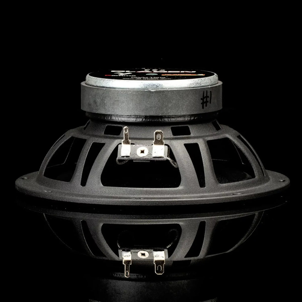 Een zwart-zilveren Gladen Gamma 165.2 AC-luidspreker is te zien tegen een zwarte achtergrond, samen met zijn spiegelbeeld – ideaal voor uw autoluidsprekersysteem.