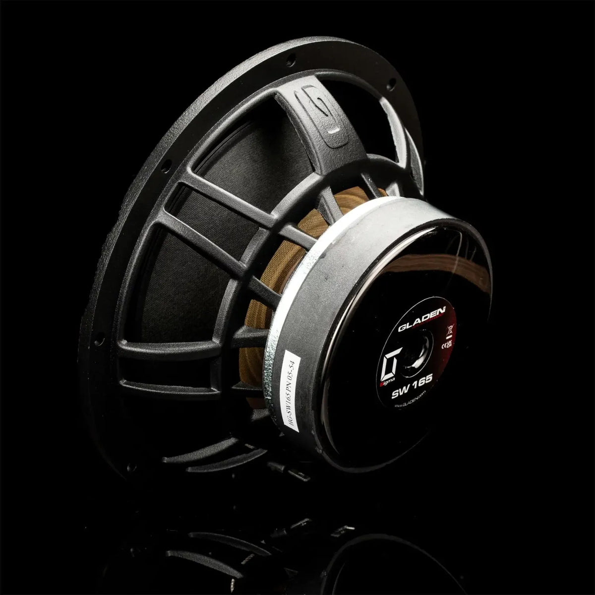 Gros plan sur un haut-parleur dautoradio Gladen Sigma 165 de 6,5 pouces avec cadre métallique, câblage apparent et étiquette, sur fond noir.