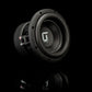 De Gladen Sigma SSWX065 5-subwoofer met een conus met structuur en zichtbare bedrading staat op een reflecterend oppervlak, waardoor de basprestaties goed tot hun recht komen tegen een donkere achtergrond.
