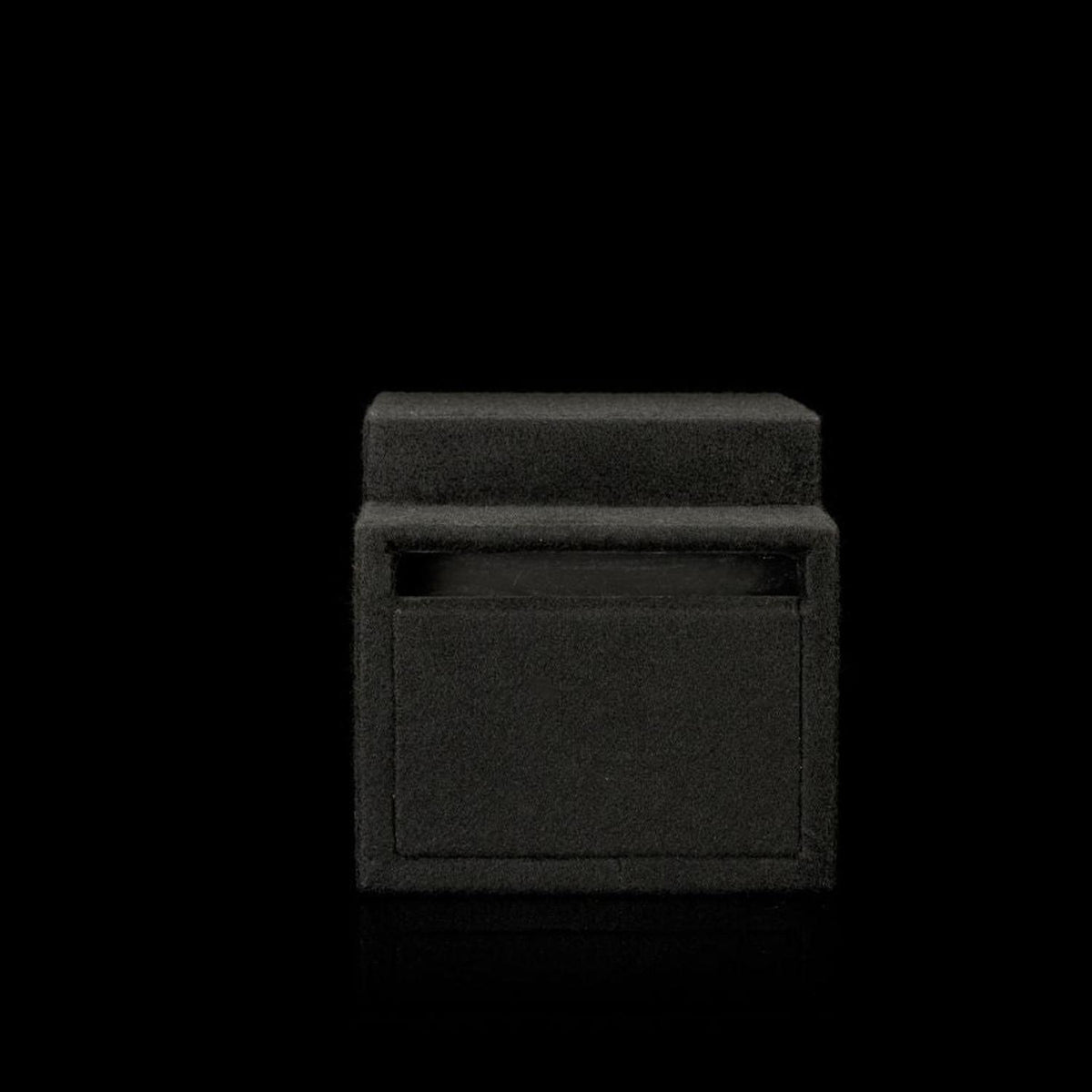 A Gladen Subbox-Buz.1 subwoofer enclosure with a closed lid is set against a black background, blending in with minimal visible detail.