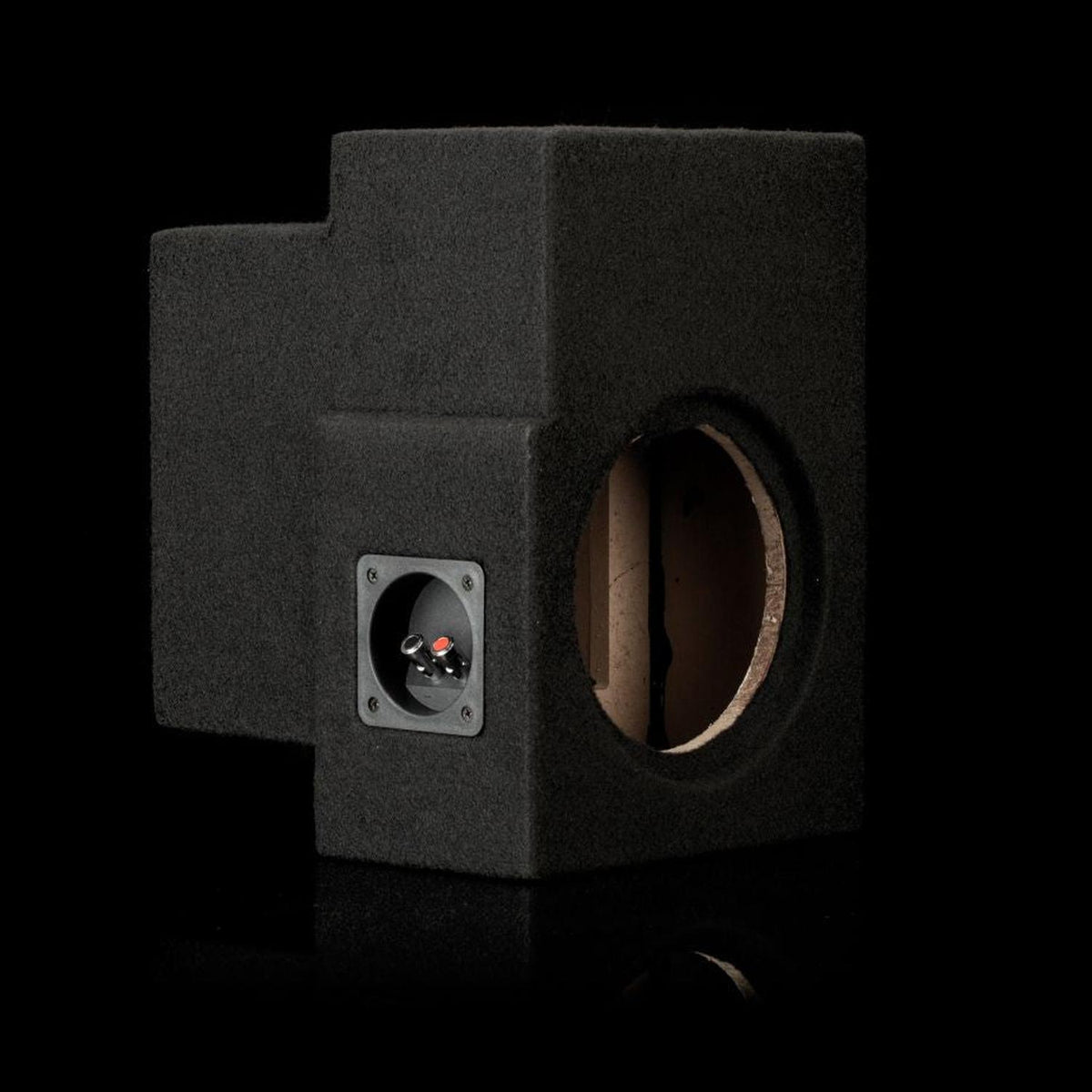 The Gladen Subbox-Buz.2 is a black carpeted bass reflex box with a round speaker cutout and terminals, shown on a black background.