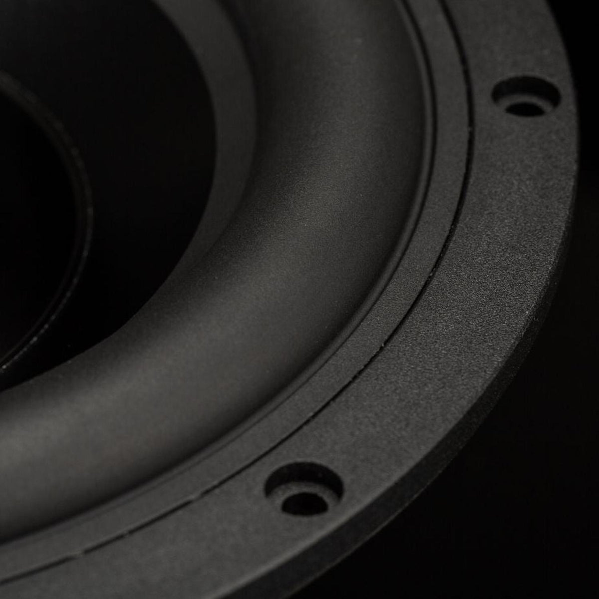 Close-up of Gladen Zeta 08 Subwoofer cone with visible screws, textured surface, and precise bass playback against a dark background.