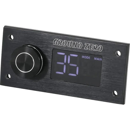 De Ground Zero GZDSP Remote PRO is een rechthoekig zwart audiobedieningspaneel met LCD-display, grote knop, kabelafstandsbediening en Ground Zero op de bovenkant.