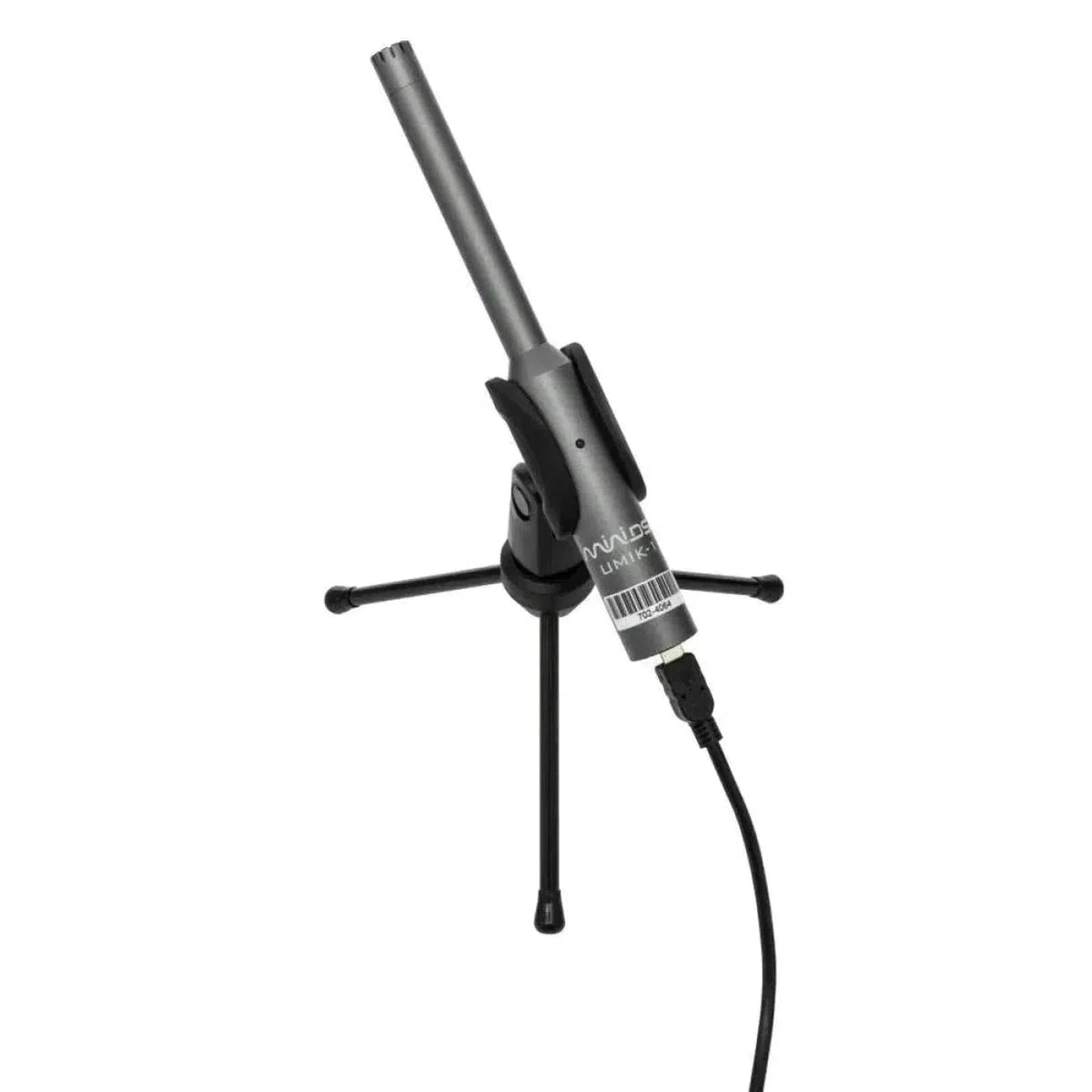 Un micrófono miniDSP UMIK-1 V3, delgado y de color gris, montado en un pequeño trípode negro con el cable conectado, situado sobre un fondo blanco liso.