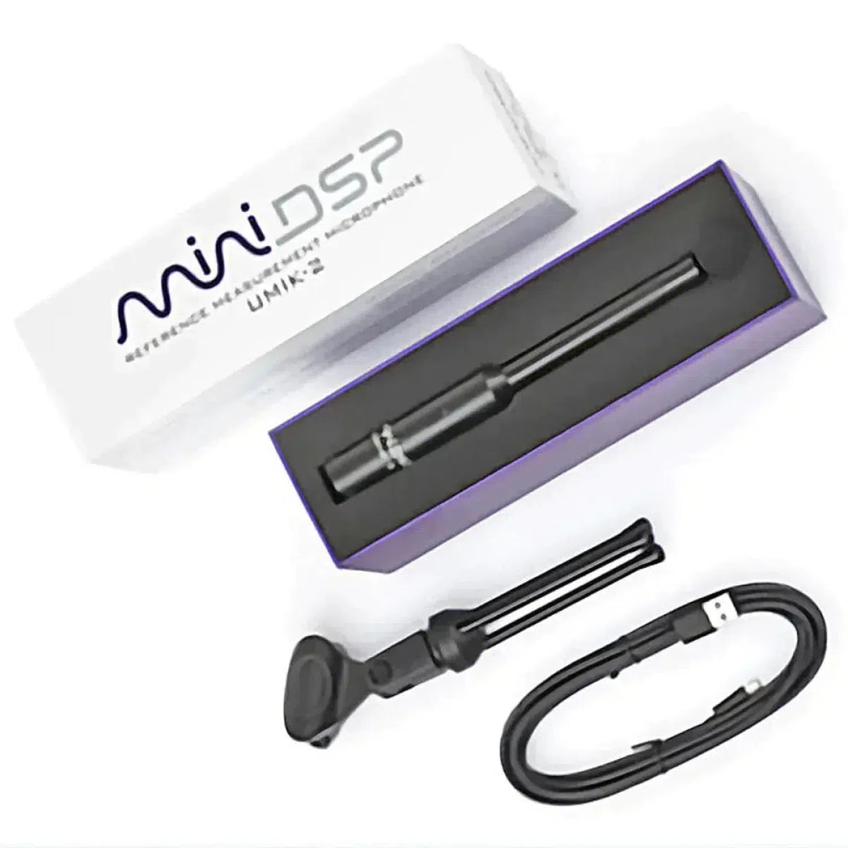 A calibrated miniDSP UMIK-2 measurement microphone with its box, USB-C cable, and mic clip is placed on a white surface.