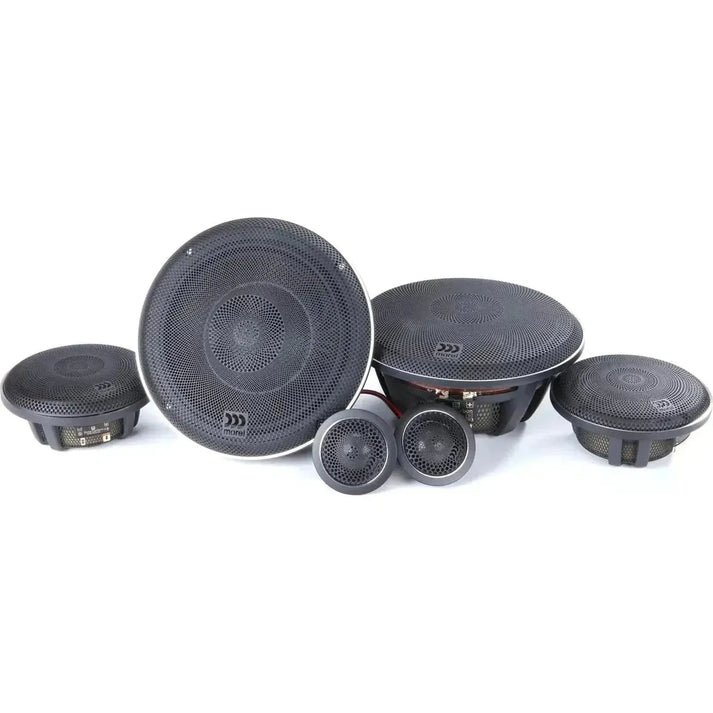 Cinque diffusori audio per auto neri, tra cui i woofer Morel Elate Carbon 63, formano un set di diffusori a 3 vie disposti su una superficie bianca.